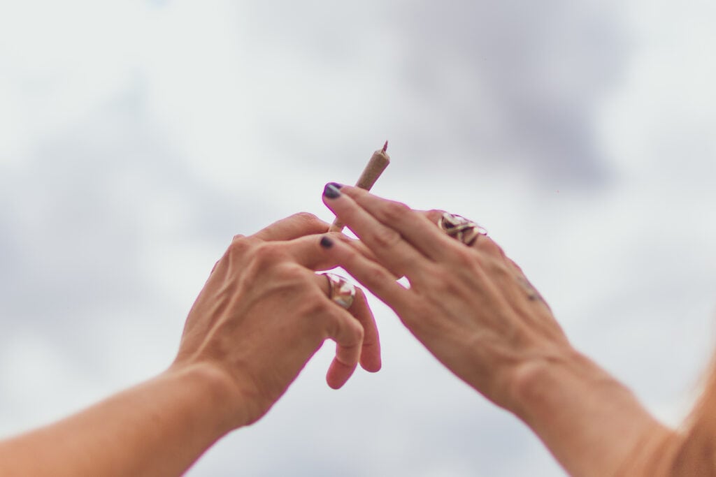 A pair of hands passing a joint between them.