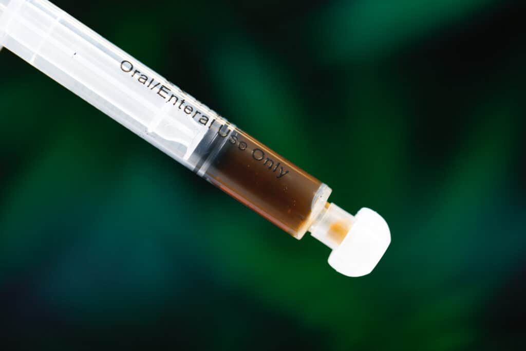 A close up photo of a syringe of RSO (Rick Simpson Oil)