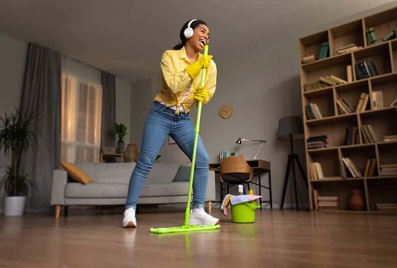 Marijuana myth busted: this young woman is cleaning the room singing, holding a mop.
